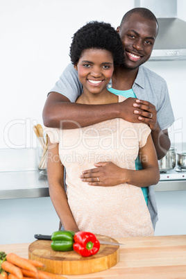 Pregnant couple embracing in kitchen