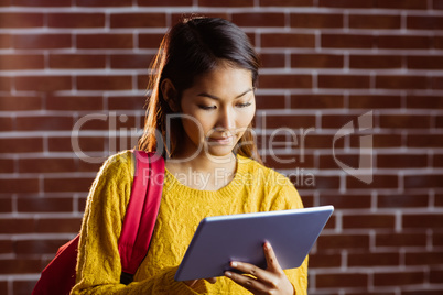 Focused asian female student using tablet