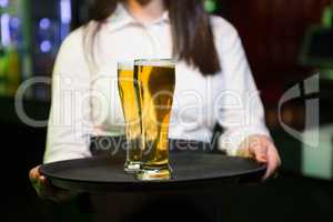 Bartender serving two glasses of beer