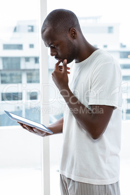 Man using digital tablet near window