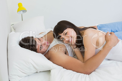 Young couple embracing on bed