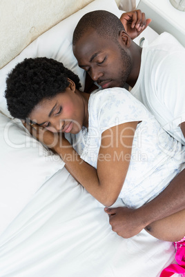 Pregnant couple relaxing on bed