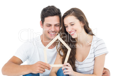 Happy couple holding house shape