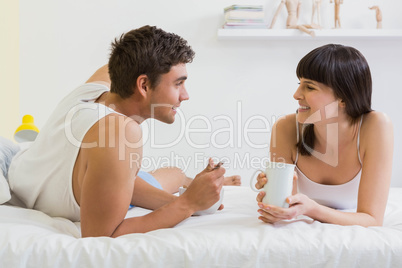 Young couple having breakfast on bed