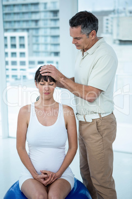 Pregnant woman receiving a massage from masseur