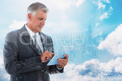 Composite image of businessman using his tablet