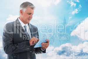 Composite image of businessman using his tablet