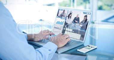 Composite image of businessman using laptop at table