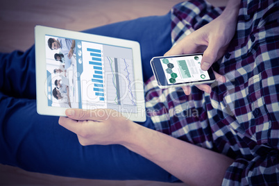 Composite image of attractive businessman using a tablet at work