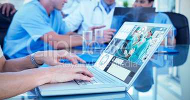 Composite image of doctor typing on keyboard with her team behin