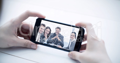 Composite image of cropped image of man holding smartphone