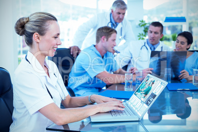 Composite image of beautiful smiling doctor typing on keyboard w