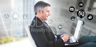 Composite image of businessman using laptop