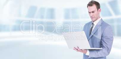 Composite image of businessman using laptop