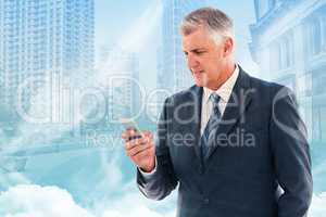 Composite image of businessman using his smartphone