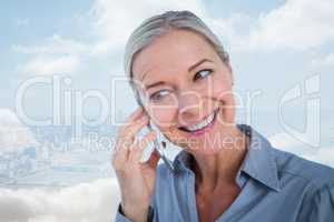 Composite image of smiling businesswoman having a phone call