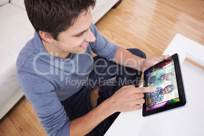 Composite image of overhead view of man using digital tablet in