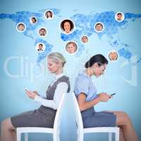 Composite image of businesswomen sitting back-to-back on the cha