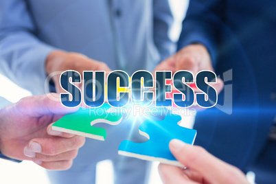 Success against business colleagues holding piece of puzzle