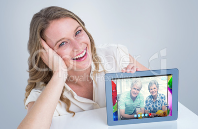 Composite image of woman showing tablet pc