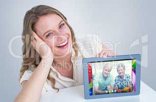 Composite image of woman showing tablet pc