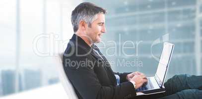 Composite image of businessman using laptop