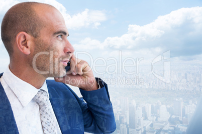 Composite image of businessman calling on the phone