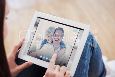 Composite image of teen using a tablet pc sitting on the floor