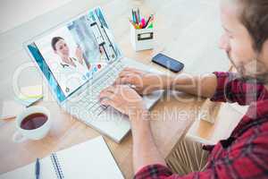 Composite image of creative businessman typing on laptop