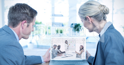 Composite image of business people looking at blank screen of la
