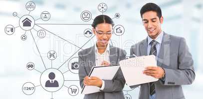 Composite image of smiling business people writing on clipboard