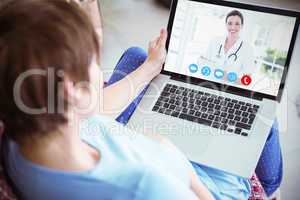 Composite image of pregnant woman using her laptop