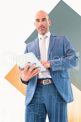 Composite image of businessman using a tablet and smiling at the