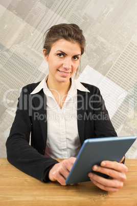 Composite image of businesswoman using her tablet pc