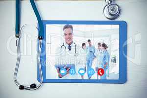 Composite image of smiling doctor holding digital tablet