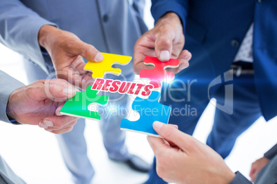 Results against business colleagues holding piece of puzzle