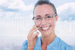 Composite image of smiling businesswoman having a phone call