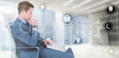 Composite image of handsome businessman using his laptop