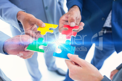 Business colleagues holding piece of puzzle