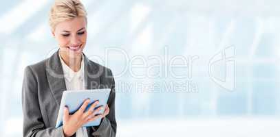 Composite image of smiling buisnesswoman using digital tablet