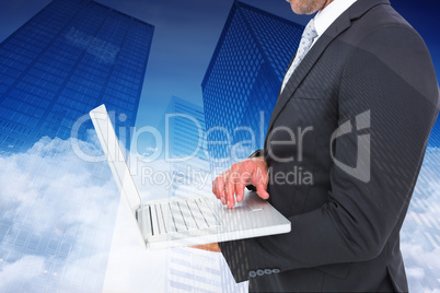 Composite image of businessman holding laptop