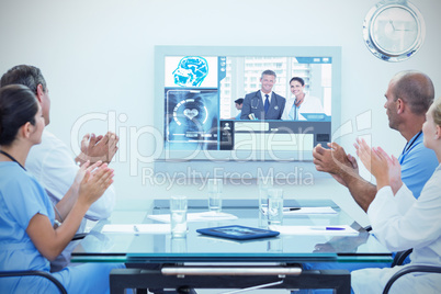 Composite image of team of doctor applauding during meeting