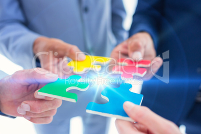 Business colleagues holding piece of puzzle