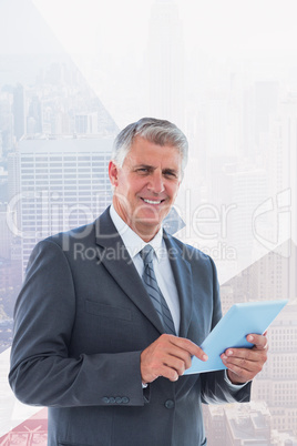 Composite image of smiling businessman using his tablet