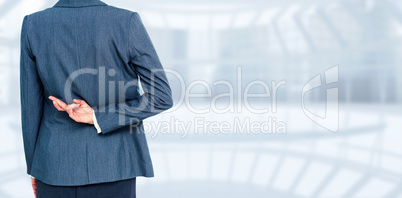 Composite image of businesswoman with fingers crossed behind her