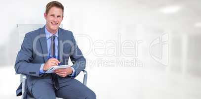 Composite image of businessman writing down on a notebook