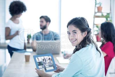 Composite image of smiling businesswoman using tablet