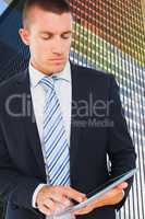 Composite image of businessman using tablet