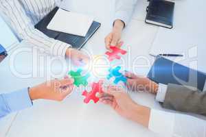 Business colleagues holding piece of puzzle