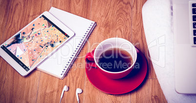 Composite image of overhead shot of laptop, tablet, coffee and h
